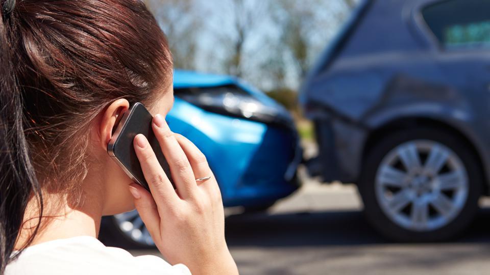 Woman on phone after her car was involved in an accident